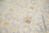 Distressed antique Khotan rug runner texture showing foundation, faded teal, ivory, apricot floral.