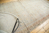 Evenly distressed antique Khotan rug, with faded teal floral motifs and apricot border.