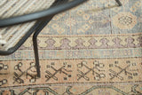 Faded teal, apricot, and mauve floral cross-section motifs on an antique Khotan runner.