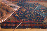 Vintage Kurdish Hamadan rug showing layered red, indigo, beige geometric borders and Herati design.
