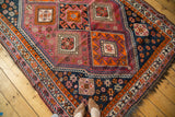 South West Persian hand-knotted carpet with vibrant tangerine, aubergine, and navy tribal geometrics.