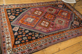 Primitive tangerine orange tribal motifs in aubergine and navy blue fields.