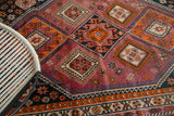 Vintage South West Persian carpet detail: geometric tribal pattern in tangerine, aubergine, navy.