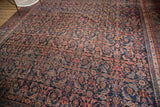 Vintage Bijar rug's Herati motif and samovar border in navy, blush, and oxidized green.