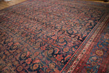 Vintage Persian Bijar carpet featuring navy blue Herati motifs and a blush-toned classic border.