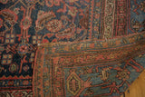 Folded vintage Persian Bijar carpet, showing worn navy and blush Herati motif with classic border.