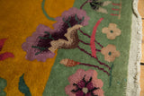Speckled gold and pistachio weaving with mauve florals and pink vinery along the rug's edge.