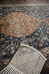 Distressed terra cotta medallion and navy blue field with intricate herati mahi design.