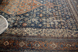 Storied navy blue field texture and detailed terra cotta and ivory border patterns.