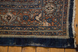 Distressed navy blue edge and worn terra cotta pattern of a vintage Bibikabad carpet.