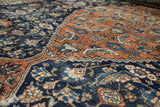 Distressed herati pattern in terracotta, navy, and ivory with serrated edge on Bibikabad rug.