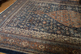 Distressed texture and intricate Herati motif in navy blue, terra cotta, and ivory.