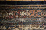Terra cotta and navy blue distressed Bibikabad rug border with varied intricate patterns.