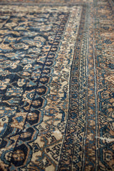 Distressed vintage Bibikabad carpet pile with herati motif and navy blue, ivory border.