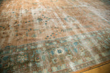 Distressed Sarouk carpet, faded sky blue floral tendrils on tan, ornate blue border.