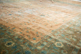 Distressed Sarouk design carpet detail showcasing blush field and ornate blue-green border.