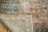 Distressed Sarouk design carpet showing worn pile, foundation, and intricate floral pattern on reverse.