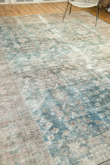 Distressed Mahal carpet's worn pile revealing faded floral blossoms in dusty teal and blush.