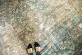Distressed Persian Mahal rug showing worn floral field in dusty teal and faded red.