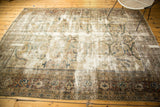 Distressed corner of the Mahal carpet, with visible ivory foundation and rust, charcoal border patterns.