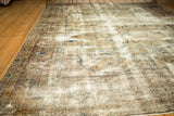 Distressed Persian Mahal carpet edge, highlighting ghosted scrolling vinery and muted antique tones.
