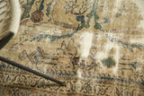 Distressed texture of a vintage Mahal carpet, revealing its antique ivory field and colorful floral design.