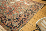 Angled detail of distressed Mahal carpet's worn floral field and rich navy samovar border.