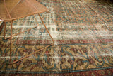 Distressed Persian Mahal carpet's worn texture, exposed foundation, and geometric border in teal, red, camel.