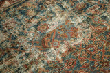 Distressed Persian carpet texture with herati motif in teal and pomegranate.