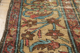 Distressed Persian Mahal carpet edge with time-softened camel, red, and teal florals.