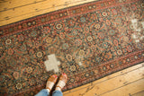 Distressed antique Fereghan runner shows worn Herati motif with exposed foundation.