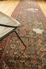 Antique Fereghan runner's distressed texture, Herati pattern in blush, dark blue, charcoal, and exposed foundation.