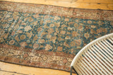 Distressed Malayer runner featuring faded sky blue Herati field and bronze crab border.