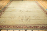 Distressed Indo Chinese carpet, showing faded ivory field medallions and pale wine red borders.