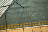 Distressed ocean green Indo Arts and Crafts carpet with visible foundation wear and saffron diamond border.