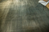 Distressed Indo Arts and Crafts square rug section with ocean green striations and visible foundation.