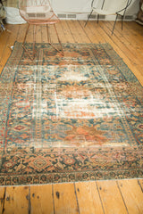 Distressed Hamadan carpet corner showing worn pile to knot heads, teal, peach, and ivory.