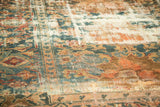 Hamadan carpet with heavily worn pile, showcasing faded teal, peach, and ivory motifs.