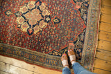 Halvaie Bijar carpet's scalloped medallion with paisley boteh on a cherry red Herati field.