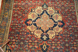 Scalloped navy and saffron medallion with paisley boteh on a cherry red Bijar rug.