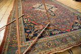 Navy rams horn spandrel and samovar border details on an antique Halvaie Bijar carpet.