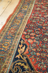 Bold navy arabesque border meets cherry red Herati field of the antique Bijar rug.