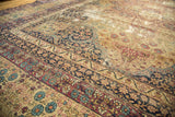 Distressed Kerman carpet showcasing time-softened pile, intricate milfleur patterns, and rich floral borders.