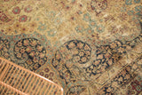 Distressed Antique Kerman carpet pile, with ivory, navy, and wine red mil fluer motifs.
