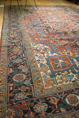 Rectilinear Heriz rug field and border detail with cherry red, sapphire blue, and ivory patterns.