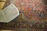 Vintage Heriz carpet's ornate border, floral arabesques in cherry red and sapphire blue.