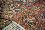 Rectilinear and curvilinear floral patterns on a vintage Heriz carpet, cherry red and sapphire blue.