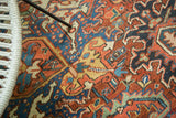 Close-up of vintage Heriz carpet with intricate curvilinear detailing in brick red and sapphire blue.