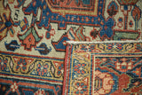 Vintage Heriz rug corner showing brick red, ivory, and blue rectilinear pile and reverse.