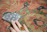 Antique Mahal carpet surface texture showing wear to knot heads, cinnabar red and green lattice.